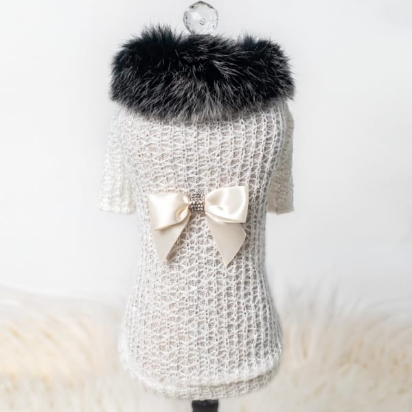Just in time for the change of season, keep your baby stylish and warm in our new sweater collection. The high society sweater is made from light soft wool and has a faux mink collar, it is accented with signature bow.